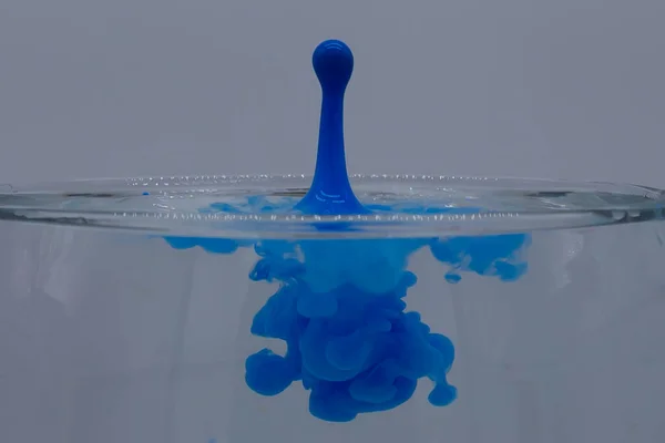 effect of a drop of paint falling onto a water solution creating abstract shapes