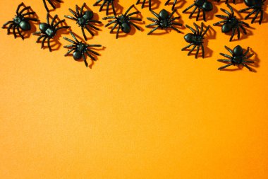 Turuncu arka planda sahte örümcekler. Cadılar Bayramı geçmişi.