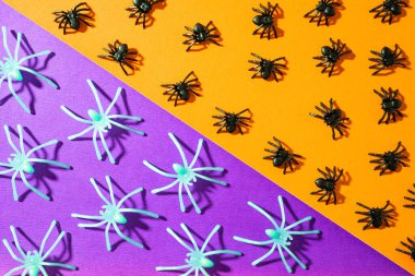 Turuncu ve mor arka planda sahte örümcekler. Cadılar Bayramı geçmişi.