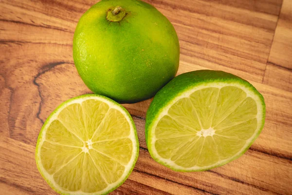 Tahta arka planda bir grup yeşil Lemon var..