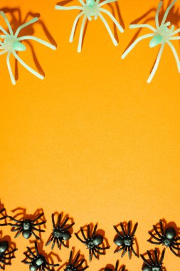 Turuncu arka planda sahte örümcekler. Cadılar Bayramı geçmişi.