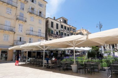 Corfu şehir, Corfu / Yunanistan 01 Haziran 2018: Cityscape Corfu town (Korfu) önünde motosiklet ile. Mağazalar, barlar ve restoranlar ile tarihsel küçük sokaklarında yürüyüş arka plan insanlara.