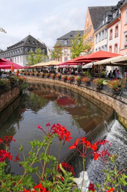 Saarburg, Rheinland-Pfalz / Almanya 24 Ağustos 2018: Saarburg şehir eski değirmenler doğru akan Cityscape tarihi eski şehir bölümü ve Leuk Nehri ile. Bar ve restoran uzun kanal oturan insanlar.