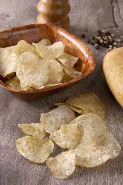 Rohe Kartoffeln Kartoffelchips Auf Einer Schüssel Und Pfeffermühle Über Holz — Stockfoto