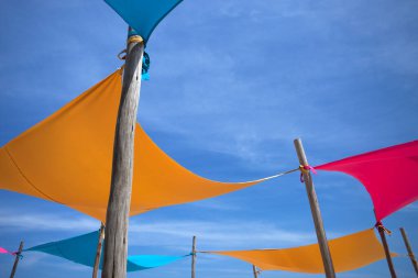 Mavi gökyüzünün altındaki Brezilya sahillerinde renkli çadırlar..