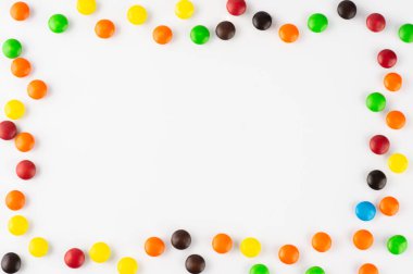 Beyaz arkaplan üzerinde renkli şekerler ve metin için yer var.