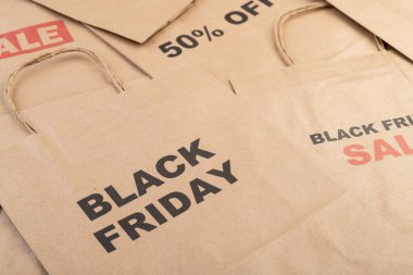 Kara Cuma ve İndirim metniyle kahverengi kağıt alışveriş torbaları.