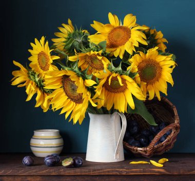 Ayçiçeği ve Erik. Natürmort çiçek ve meyve tablo ile.