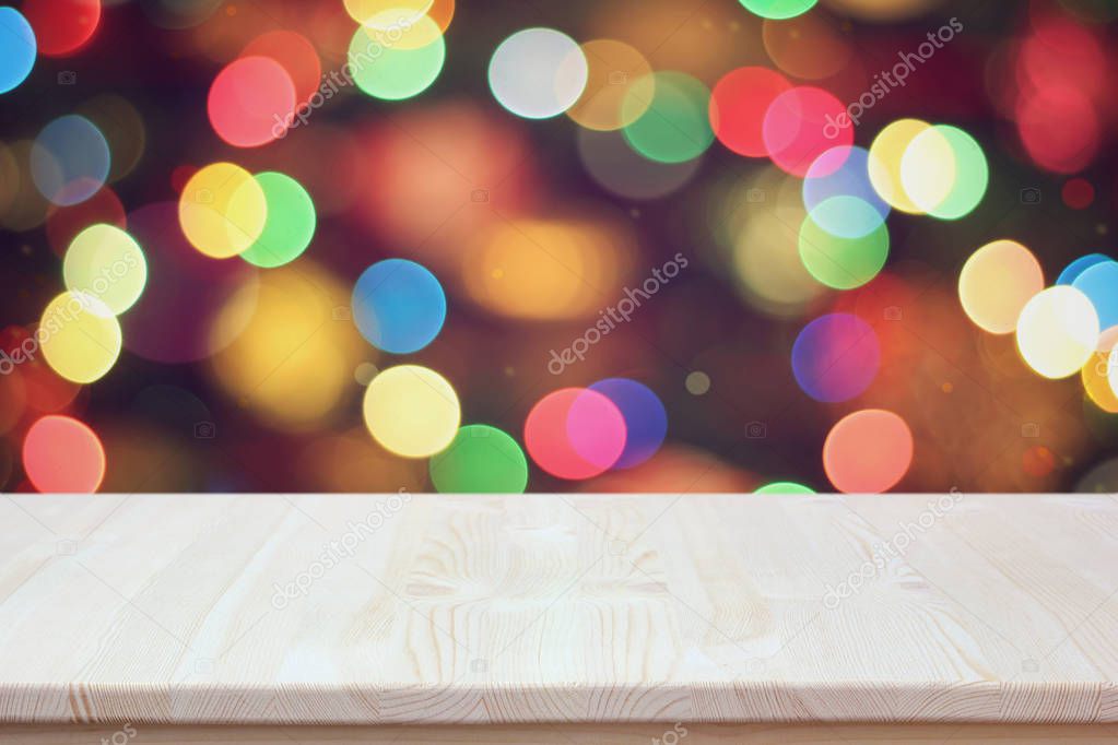 New year background: empty wooden table on blurred backdrop. Work surface, countertop or layout for installation of festive objects. 