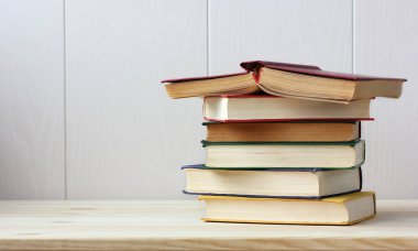 Bookshelf üzerinde kitap yığını. Ders kitapları. Soldaki metin için boş alanı. Eğitim, edebiyat, okuma.