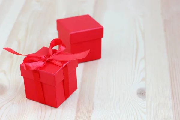 Δύο κόκκινα κουτιά σε ένα ξύλινο τραπέζι, επιλεκτική εστίαση. δώρο, συσκευασία — Φωτογραφία Αρχείου