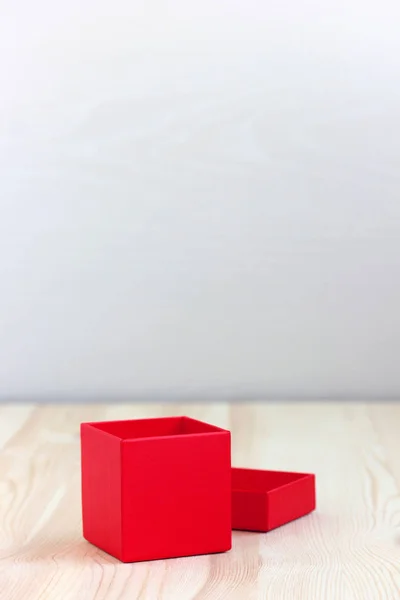 Rote Schachtel mit offenem Deckel auf Holztisch, selektiver Fokus. — Stockfoto