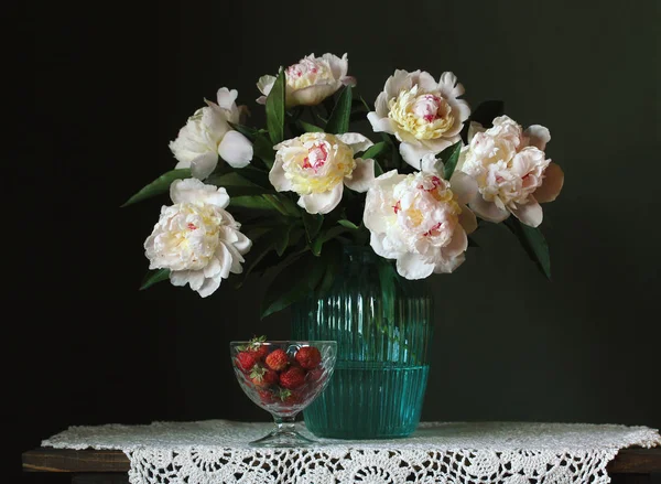 暗い背景に白い牡丹とイチゴの花束. — ストック写真