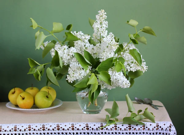 Frühlingsstillleben mit einem Strauß weißer Flieder und Äpfel — Stockfoto