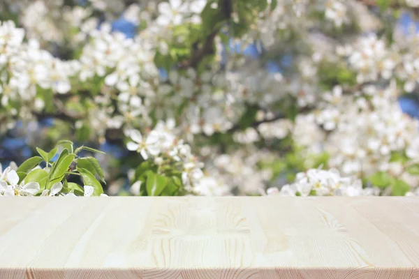 Mesa de madera vacía sobre un fondo borroso primavera con floración — Foto de Stock