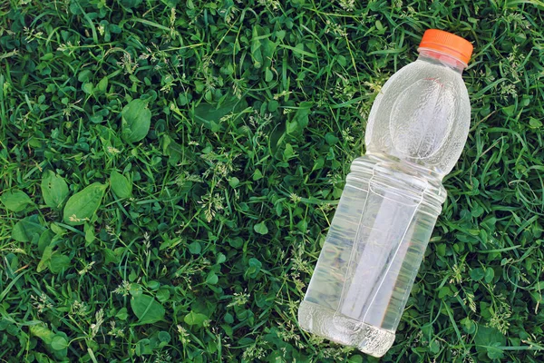 Botella de agua potable limpia sobre un fondo de hierba, vista superior . —  Fotos de Stock
