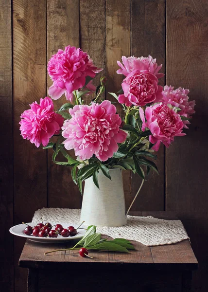 Pink peonies and cherries. rural still life. — Stock Photo, Image