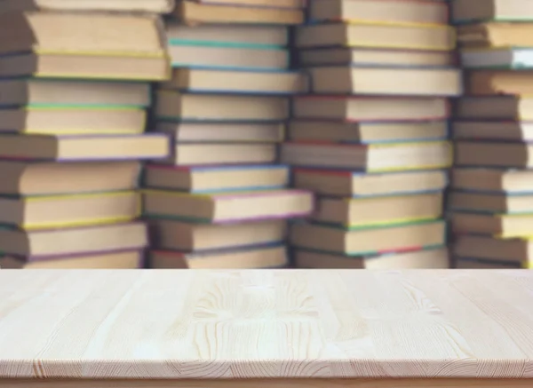 Töm träbord på suddig bakgrund av böcker. tomt skrivbord. — Stockfoto