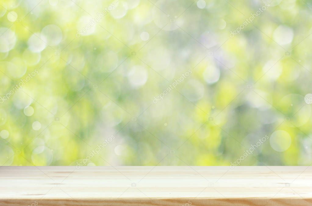 Empty wooden table top on blurred spring background.