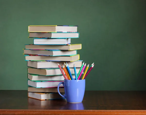 Stapel boeken en gekleurde potloden op de tafel. terug naar school. — Stockfoto
