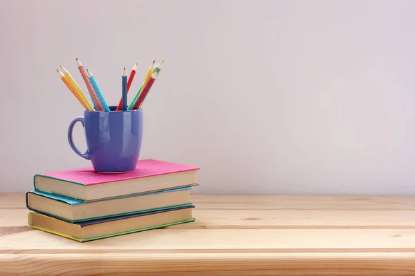 Leerboeken in kleur covers en gekleurde potloden op de tafel. Terug — Stockfoto