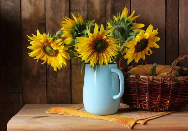 Strauß Sonnenblumen in einem Krug und einem Kürbis. — Stockfoto