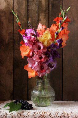 Masanın üzerinde güzel bir buket gladioli ve üzüm var. Güz Ga