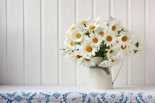 Bukett Med Trädgårdsprästkragar Bordet Med Spetsduk Blommor Burk Ljus Bakgrund — Stockfoto