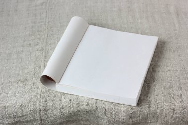 Masanın üstünde boş bir sayfa olan açık bir kitap, üst görünüm. Model, sahne oluşturucu. 