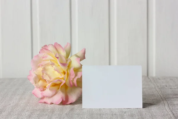 empty business card and a rose flower on the table. mockup, scene creator.
