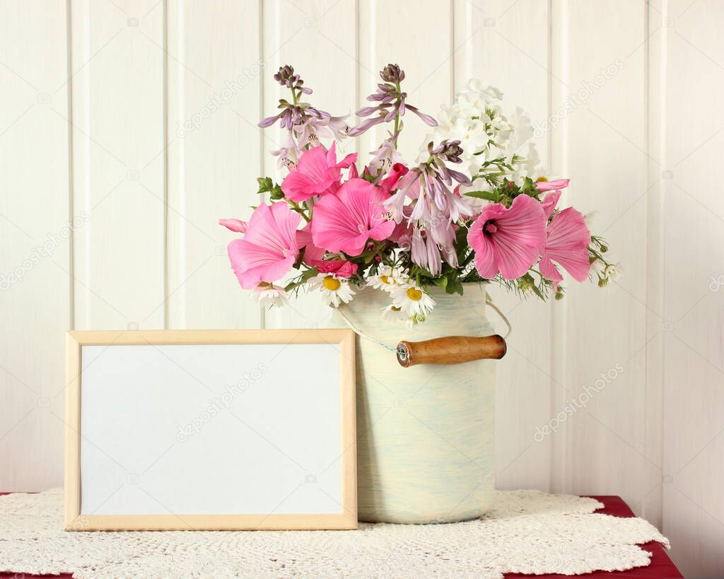 mockup, scene creator with an empty frame and garden flowers. composition with a bouquet in a can.