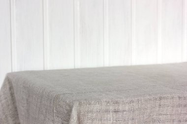 Beyaz tahta duvara karşı gri masa örtüsü olan boş bir masa. Geçmişi. Model, sahne oluşturucu.