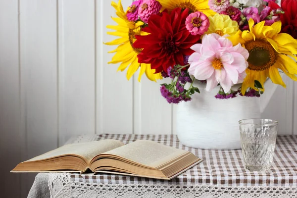 白い背景に開いた本とテーブルの上の花束でまだ生きています 選択的焦点 — ストック写真
