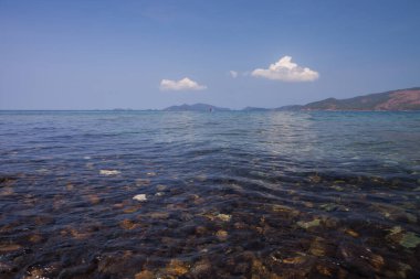 Manzara sahili ve kayalar mavi gökyüzünün altında Tayland 'ın güneyinde yer alan dağ arkaplanı.