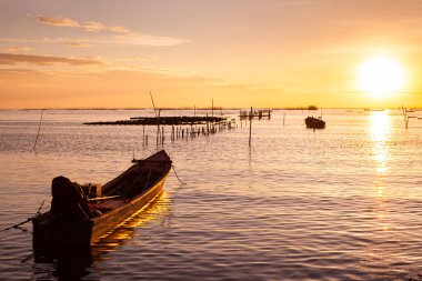 Tayland 'ın doğusundaki Chonburi bölgesinde gün batımında renkli gökyüzünün altında bir tekne yüzüyor.