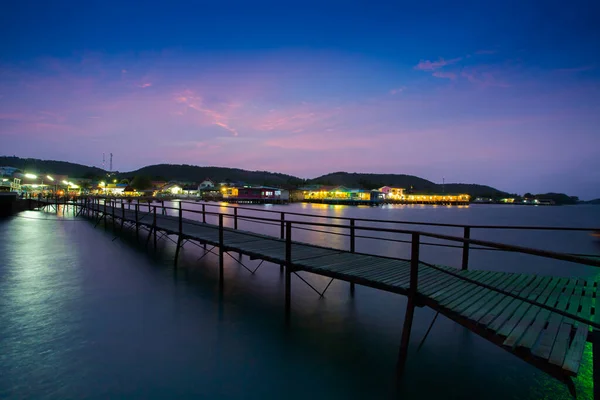 Renkli gökyüzünün altında, Pattaya, Tayland 'da bulunan renkli tatil beldesi ve dağ arkaplanı ile gece vakti denizde bir yürüyüş.