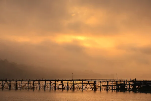 Ponte Madeira Através Rio Com Fundo Nebuloso Nascer Sol Reflexão — Fotografia de Stock