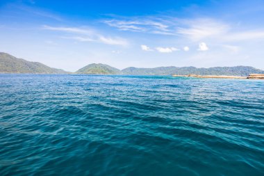 Dağın arka planında berrak bir deniz dalgası. Tropicana 'da açık gökyüzü altında, Tayland' ın güneyinde.