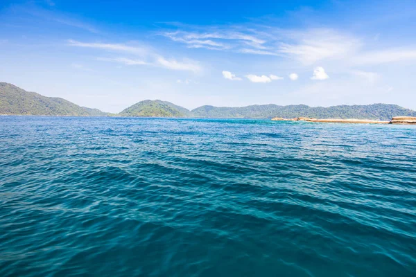 Dağın arka planında berrak bir deniz dalgası. Tropicana 'da açık gökyüzü altında, Tayland' ın güneyinde.
