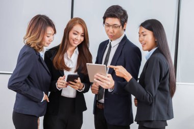 Genç iş adamları iPad 'e odaklanıyor ve beyaz arka planda gülümsüyor.