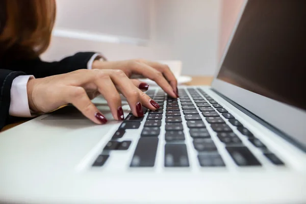 Business people are hand typing on silver color laptop computer put on table