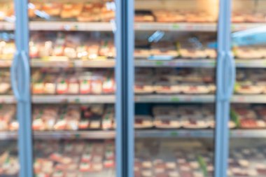 Süpermarkette tüketici ürünleri satan rafların bulanık görüntüsü