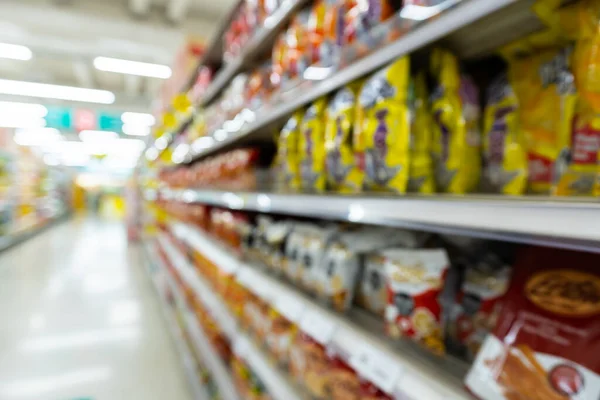 Süpermarkette tüketici ürünleri satan rafların bulanık görüntüsü