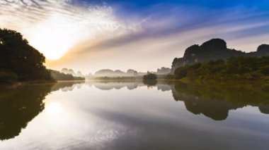 Tayland 'ın kuzeyindeki gölde gün doğumu yansıması.