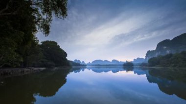 Tayland 'ın kuzeyindeki gölde gün doğumu yansıması.
