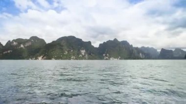 Barajdaki bulutlu gökyüzü yansımasının altındaki dağ manzarası