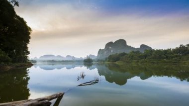 Tayland 'ın kuzeyindeki gölde gün doğumu yansıması.