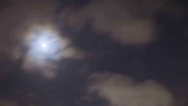 Une Lune se déplace rapidement dans le ciel sombre la nuit passée par nuageux
