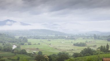 Dağda açık mavi gökyüzünün altında beyaz bulutlu hareket