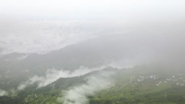 Dağda açık mavi gökyüzünün altında beyaz bulutlu hareket